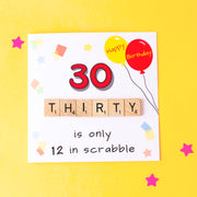 30 is only 12 in Scrabble. 30th Birthday Card. Illustrated with party balloons and confetti and hand finished with wooden scrabble tiles. Image on yellow background