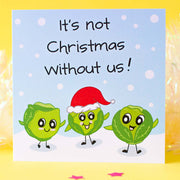 Illustrated Christmas card by fizzi-jayne. Three Cute Kawaii style sprouts, one with a Santa hat on, in the snow with handlettering that says, It's Not Christmas Without us!