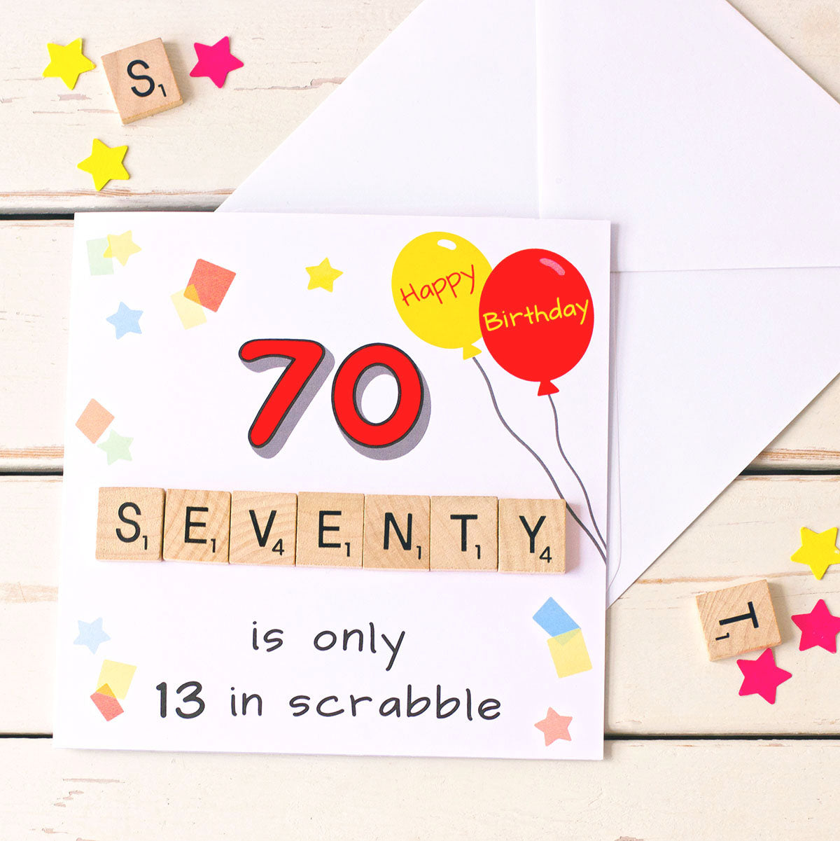 70 is only 13 in scrabble. 70th birthday card with white envelope. Illustrated with birthday balloons and confetti and hand finished with wooden scrabble tiles