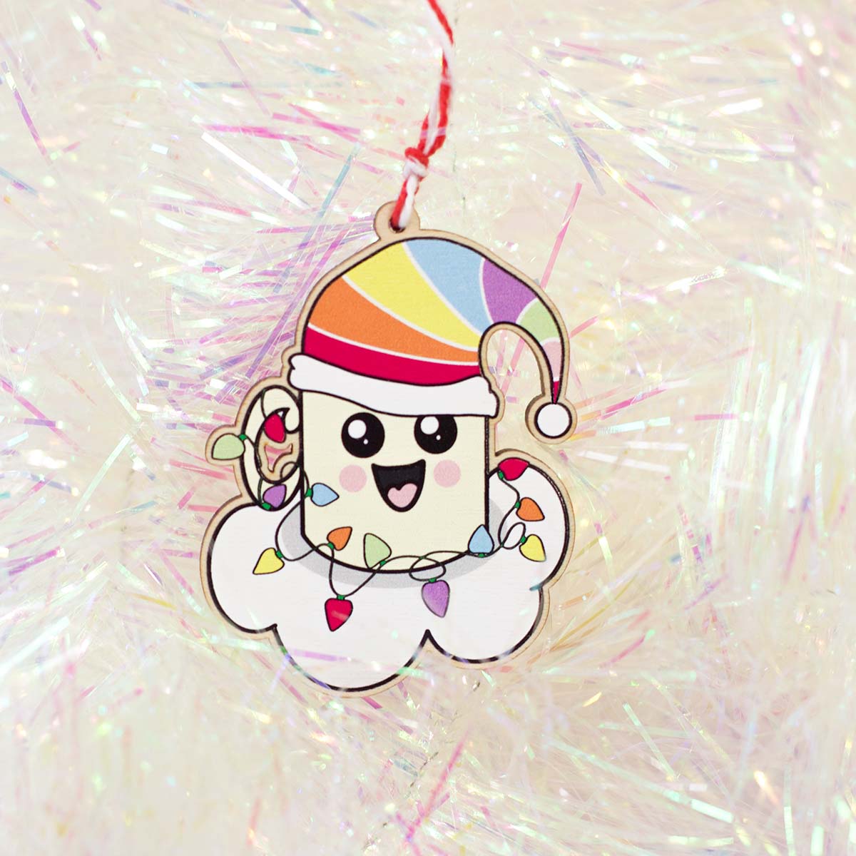 happy, Kawaii style mug on a cloud with a rainbow Santa hat with Christmas lights wrapped around it on white tinsel