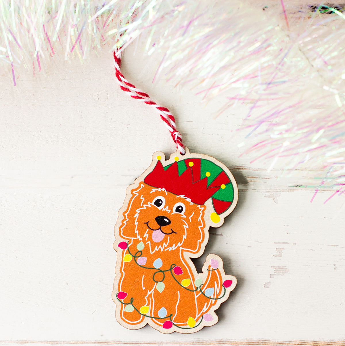 cheeky festive cockapoo christmas decoration illustrated in a gingerbread style printed on to wood with red and white twine