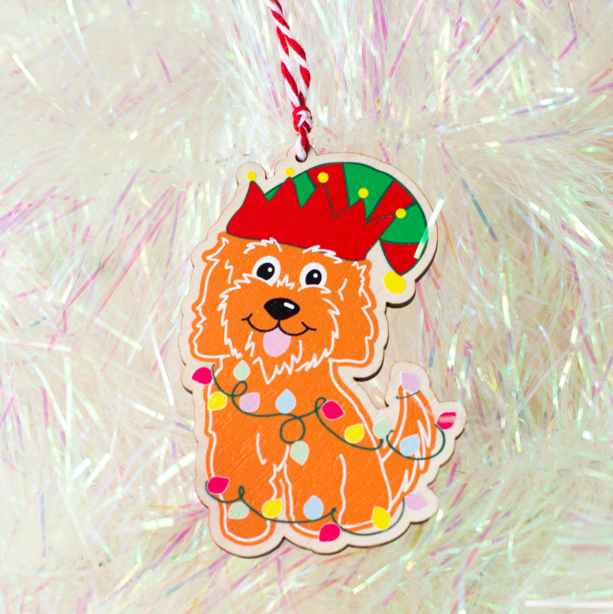 Gingerbread style cockapoo christmas tree decoration. illustrated wrapped in fairy lights and an elfs hat