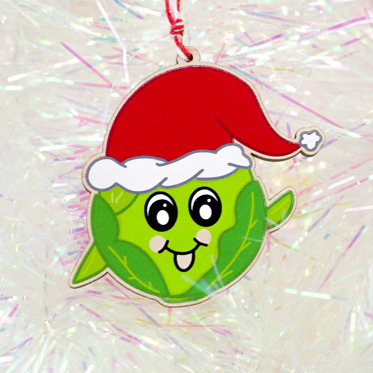 Kawaii style illustration of a happy sprout with a Santa hat printed on to wood and laser cut. 