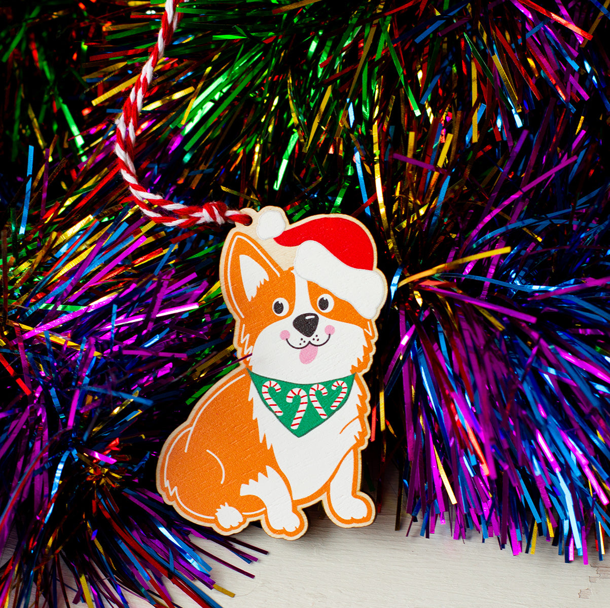 Gingerbread style corgi dog with a santa hat and a bandana with candy canes on it